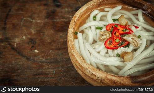 closeup of udon noodle in wood bowl on wooden floor background