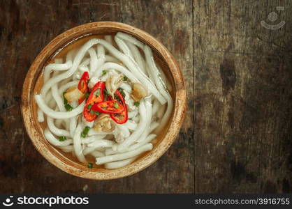 closeup of udon noodle in wood bowl on wooden floor background