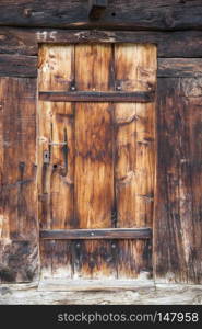 closeup of very old grungy brown wooden weathered planks of door in ancient swiss barn