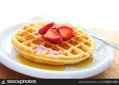 Closeup of waffle with fresh strawberries and syrup with copy space