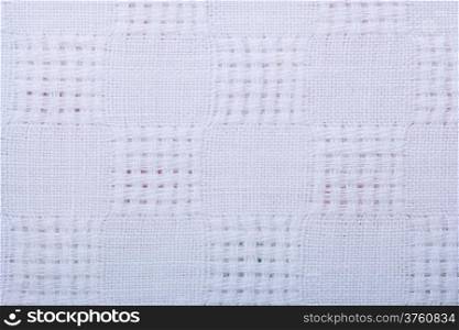 Closeup of white fabric textile as background texture pattern backdrop. Macro.