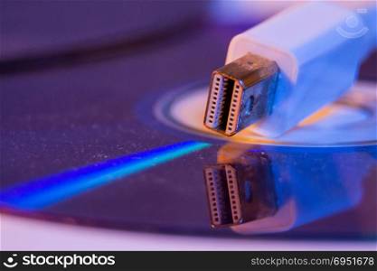Closeup of white Mini Displayport cable with it&rsquo;s reflection on blank disc.