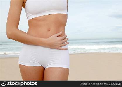 Closeup of woman&acute;s body stretching on the beach