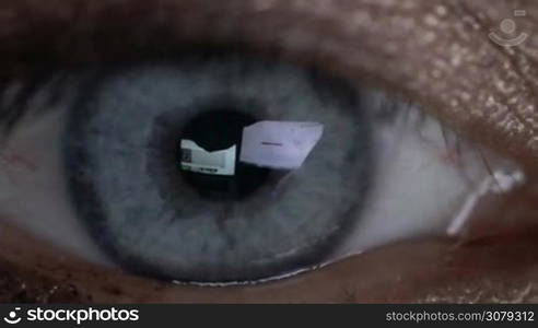 Closeup of woman&acute;s eye in glasses works on laptop at night. Macro young woman in glasses surfing on Internet