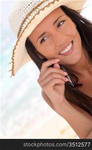 Closeup of woman at the beach with straw hat