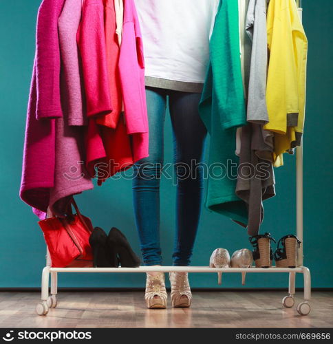 Closeup of woman choosing clothes to wear in wardrobe. Girl customer shopping in mall shop. Fashion clothing sale concept.. Woman choosing clothes to wear in mall or wardrobe
