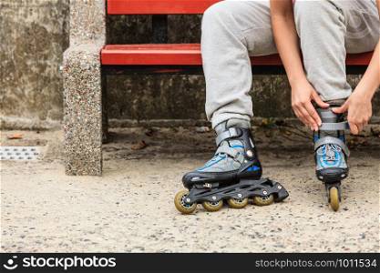 Closeup of woman girl putting on roller skates outdoor.. Woman putting on roller skates outdoor.