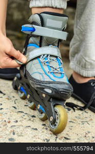 Closeup of woman girl putting on roller skates outdoor.. Woman putting on roller skates outdoor.