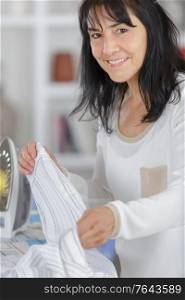 closeup of woman ironing clothes on ironing board