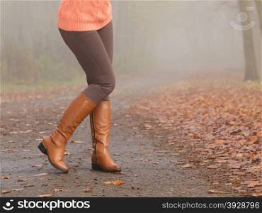 Closeup of woman legs in brown boots. Fall fashion. Closeup of woman legs in brown boots. Girl in autumn park forest. Fall winter fashion.