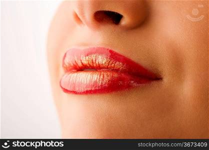 closeup of woman mouth with red and golden colored lips