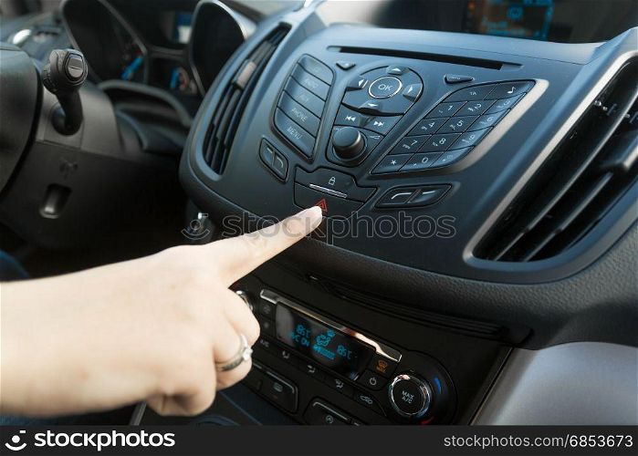 Closeup of woman pressing red car emergency button