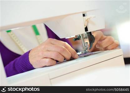 Closeup of woman using sewing machine