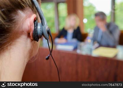 Closeup of woman wearing headset in conference room
