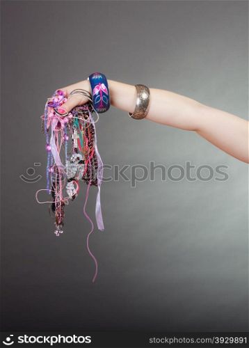 Closeup of woman with jewelry necklaces beads.. Closeup of woman hand palm holding many plentiful of precious jewelry necklaces beads. Fashion girl in studio on gray.