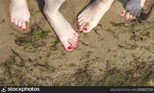 Closeup of women feet on beach sand.. Closeup of women feet.