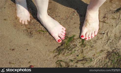 Closeup of women feet on beach sand.. Closeup of women feet.
