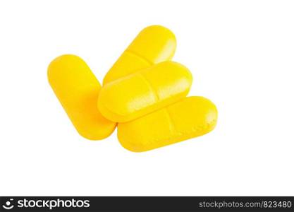 Closeup of yellow pills isolated on white background