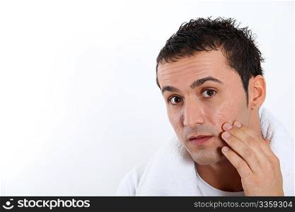 Closeup of young man putting moisturizer on his face