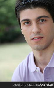 Closeup of young man sitting in a park