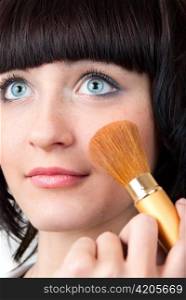 closeup of young woman applying cosmetics