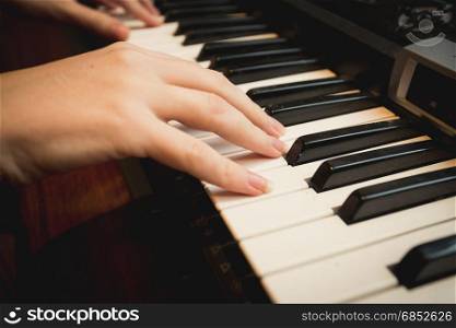 Closeup of young woman playing on piano