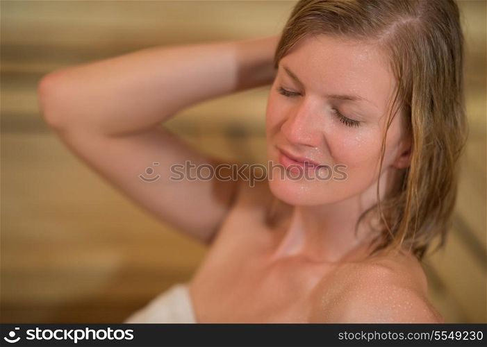 Closeup of young woman sweating in sauna