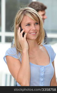 Closeup of young woman with mobile phone at college campus