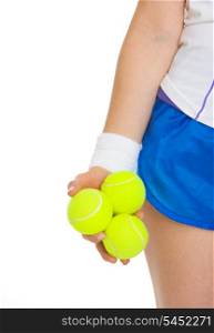 Closeup on 3 tennis balls in hand of tennis player