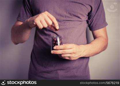 Closeup on a man getting purple candy from a small jar