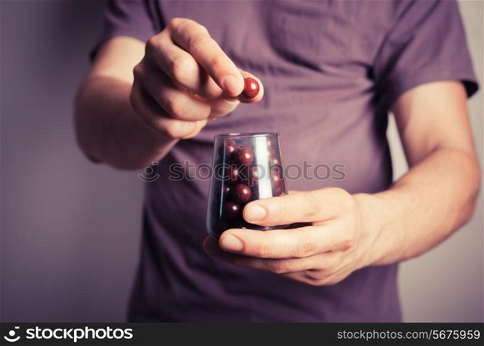 Closeup on a man offering candy from a small jar