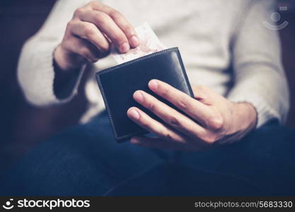 Closeup on a man&rsquo;s hands as he is getting a banknote out of his wallet