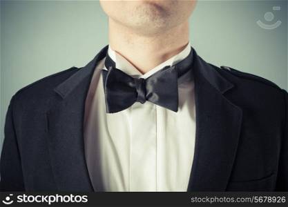 Closeup on a young man wearing a bow tie and a dinner jacket tuxedo