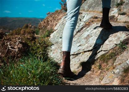 Closeup on a young woman&rsquo;s feet and legs as she is trekking in the mountains