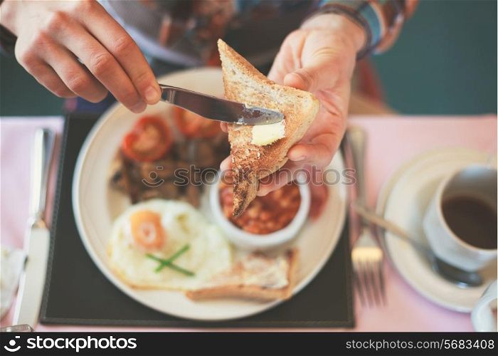 Closeup on a young woman&rsquo;s hands as she is having breakfast