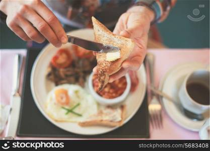Closeup on a young woman&rsquo;s hands as she is having breakfast