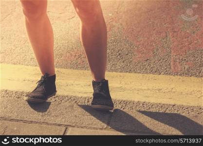 Closeup on a young woman&rsquo;s legs as she is standing in the street