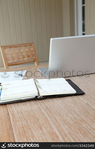 Closeup on agenda and laptop computer on table