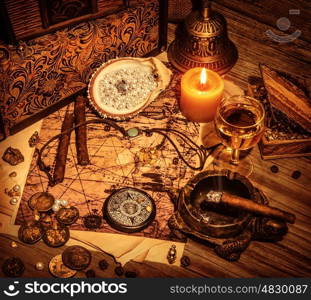 Closeup on beautiful buccaneer treasure background, luxury pirates alcohol drink, cigars, compass, pearl beads, drawing map, piracy lifestyle concept