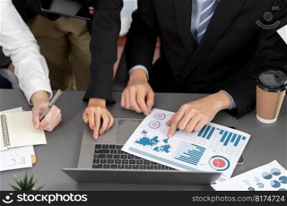 Closeup on BI dashboard on meeting desk with businesspeople analyzing or planning business strategy with hands pointing on financial paper reports as concept of harmony in office workplace.