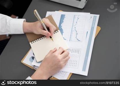 Closeup on BI dashboard on meeting desk with businesspeople analyzing or planning business strategy with hands pointing on financial paper reports as concept of harmony in office workplace.. Closeup focus on BI dashboard with office worker in harmony office.