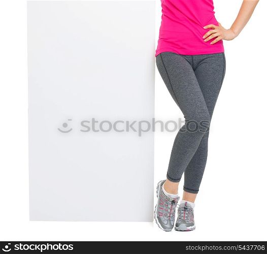 Closeup on blank billboard and fitness young woman legs
