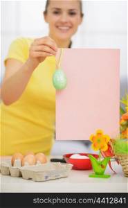 Closeup on blank pink paper sheet with Easter egg holding by woman