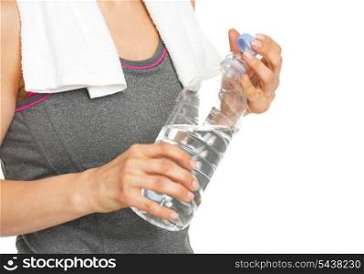 Closeup on bottle of water in hand of healthy young woman