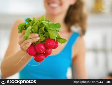 Closeup on bunch of radishes in hand of woman