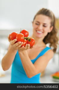 Closeup on bunch of tomato in hand of young woman