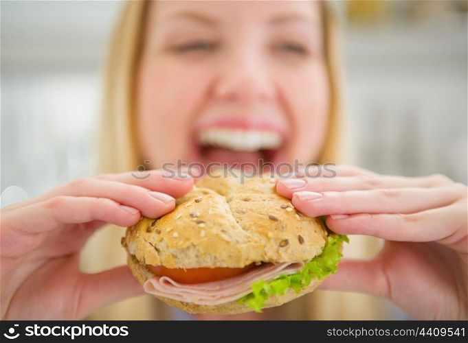 Closeup on burger in hand of smiling teenager girl