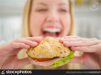 Closeup on burger in hand of smiling teenager girl