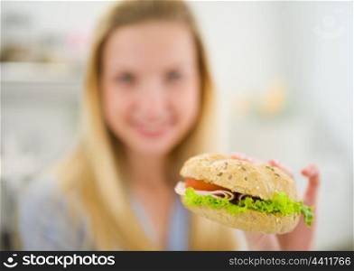 Closeup on burger in hand of teenager girl