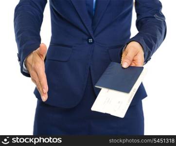Closeup on business woman giving passport with air tickets and stretching hand for handshake